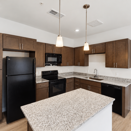 Apartment kitchen with brown cabinets and granite countertops