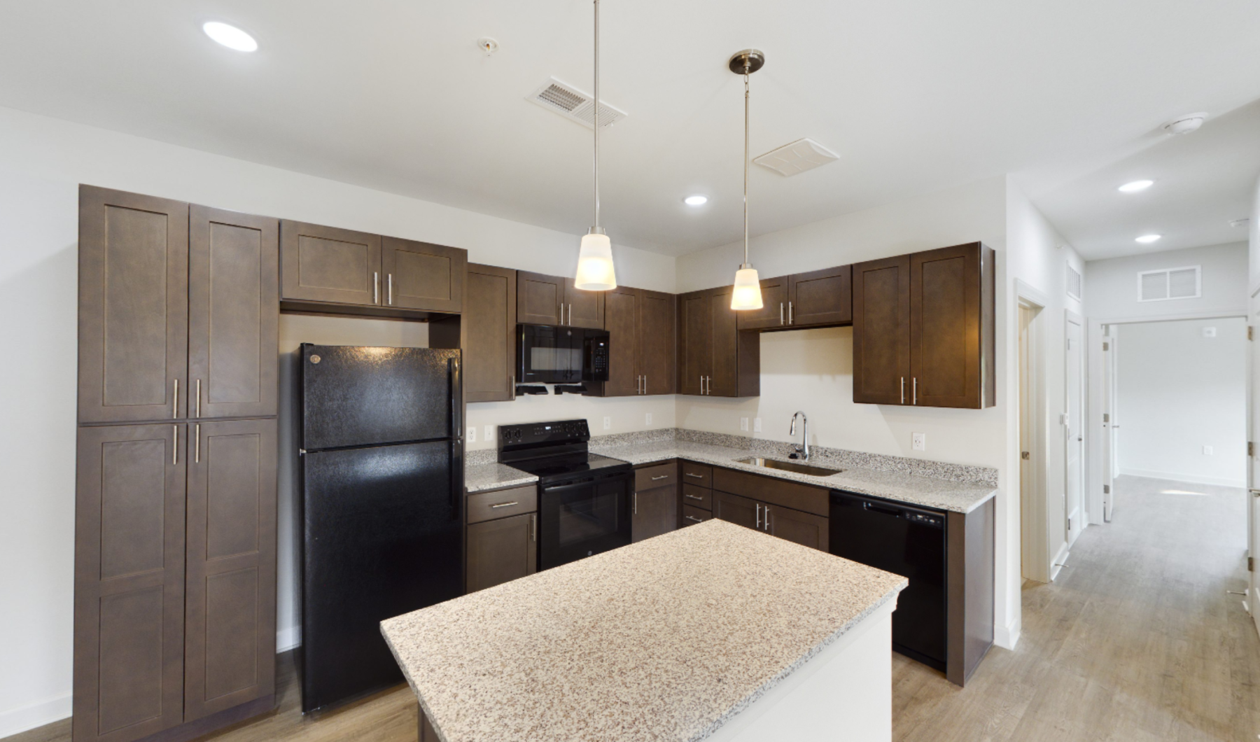 Apartment kitchen with brown cabinets and granite countertops