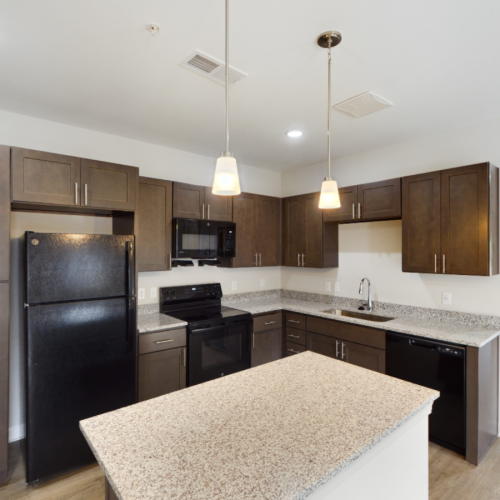 Apartment kitchen with brown cabinets and granite countertops