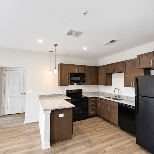 Apartment kitchen with brown cabinets and granite countertops