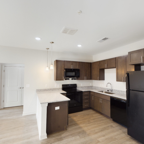 Apartment kitchen with brown cabinets and granite countertops