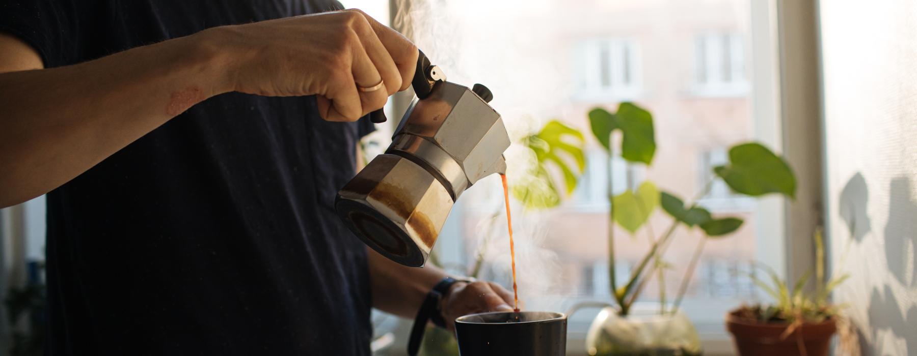 a man pouring a drink into a cup